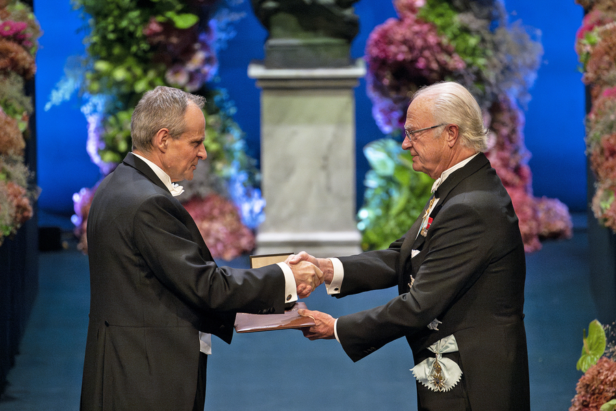 Simon Johnson shakes the hand of King Carl of Sweden during the Nobel Prize ceremony